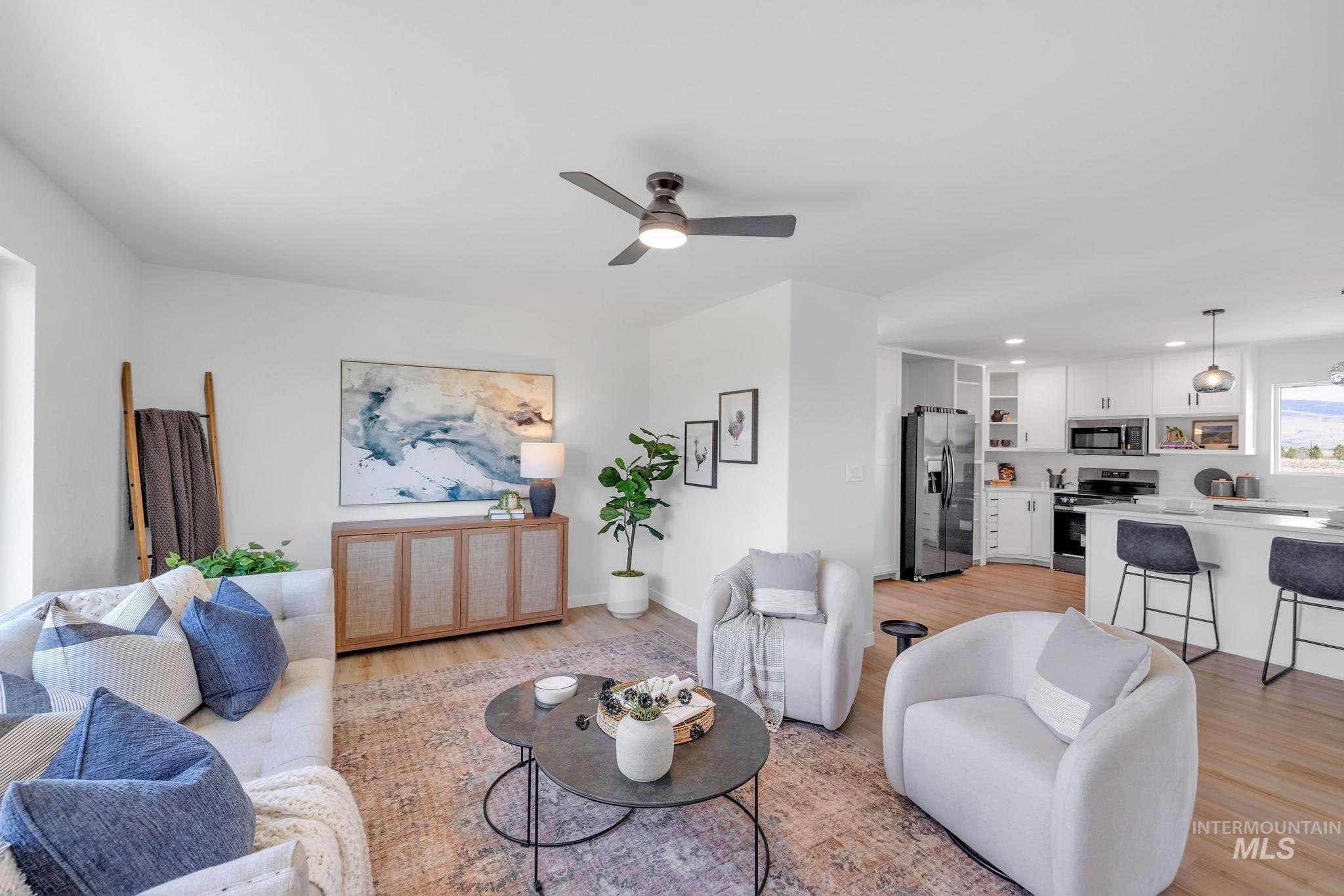 Living area featuring light wood finished floors, a ceiling fan, and recessed lighting