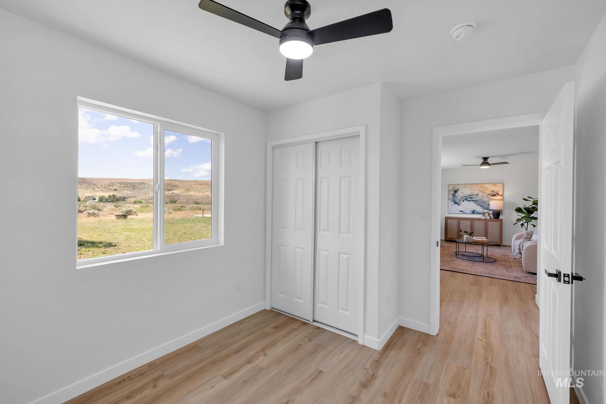 Unfurnished bedroom featuring light wood-style flooring, a closet, and ceiling fan