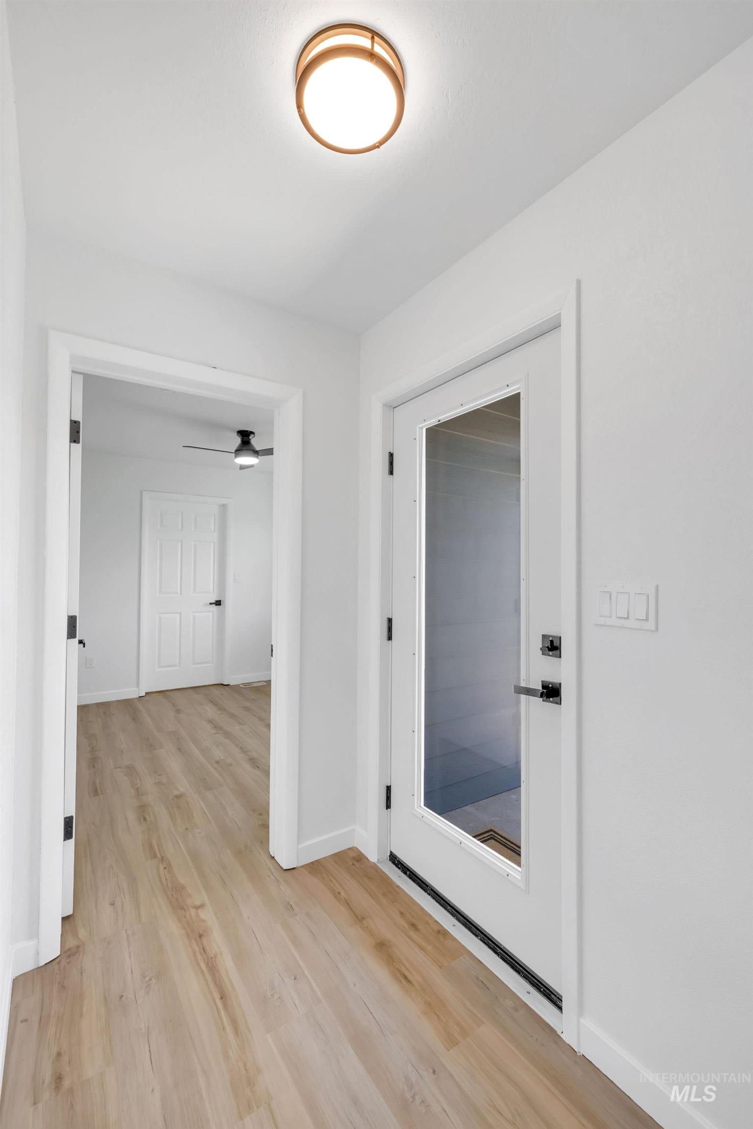 Corridor featuring light wood-type flooring and baseboards