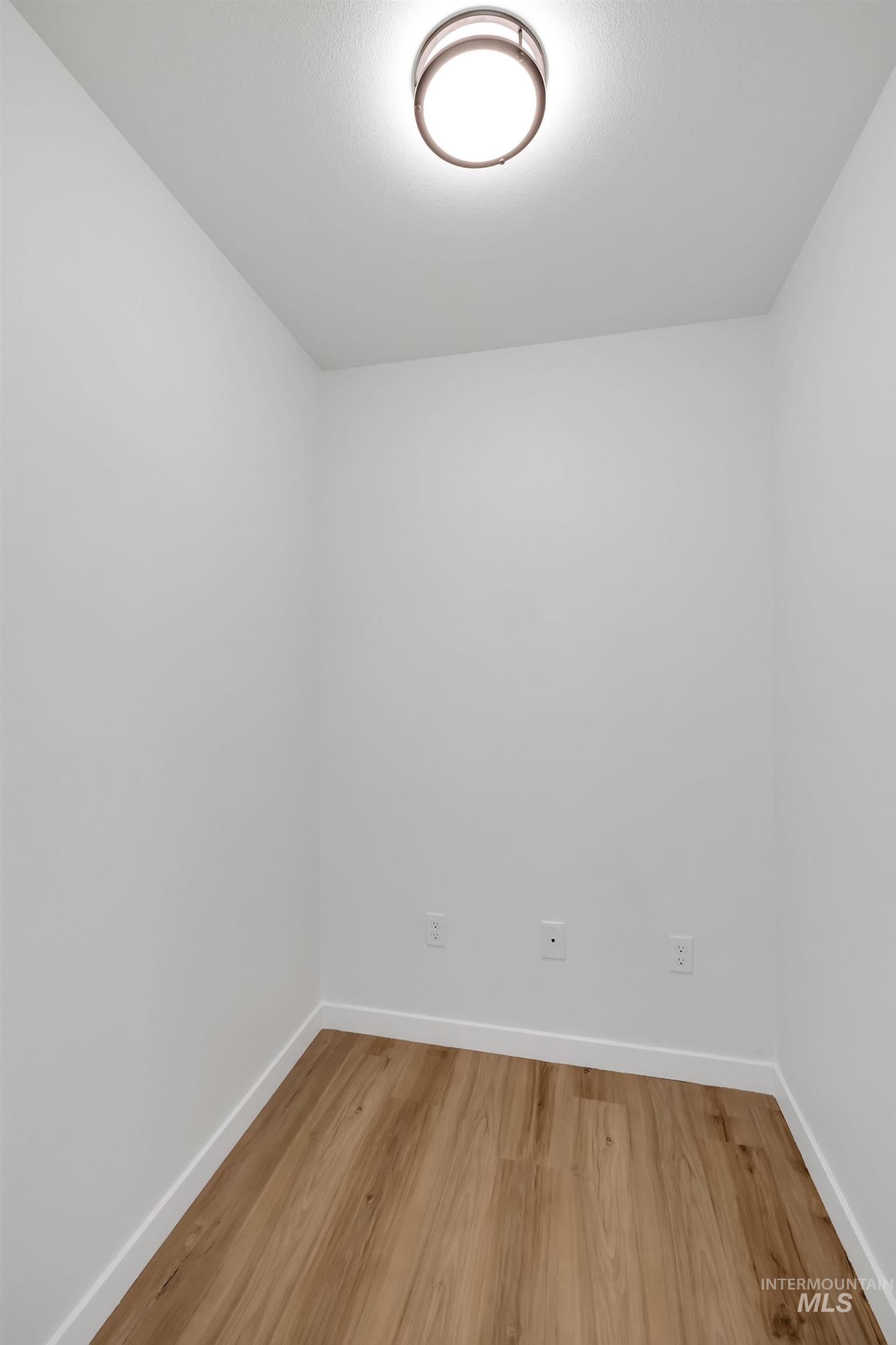 Empty room with baseboards and light wood-type flooring