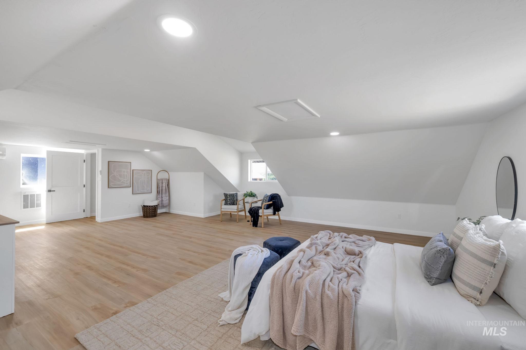 Bedroom featuring vaulted ceiling, recessed lighting, attic access, and light wood finished floors