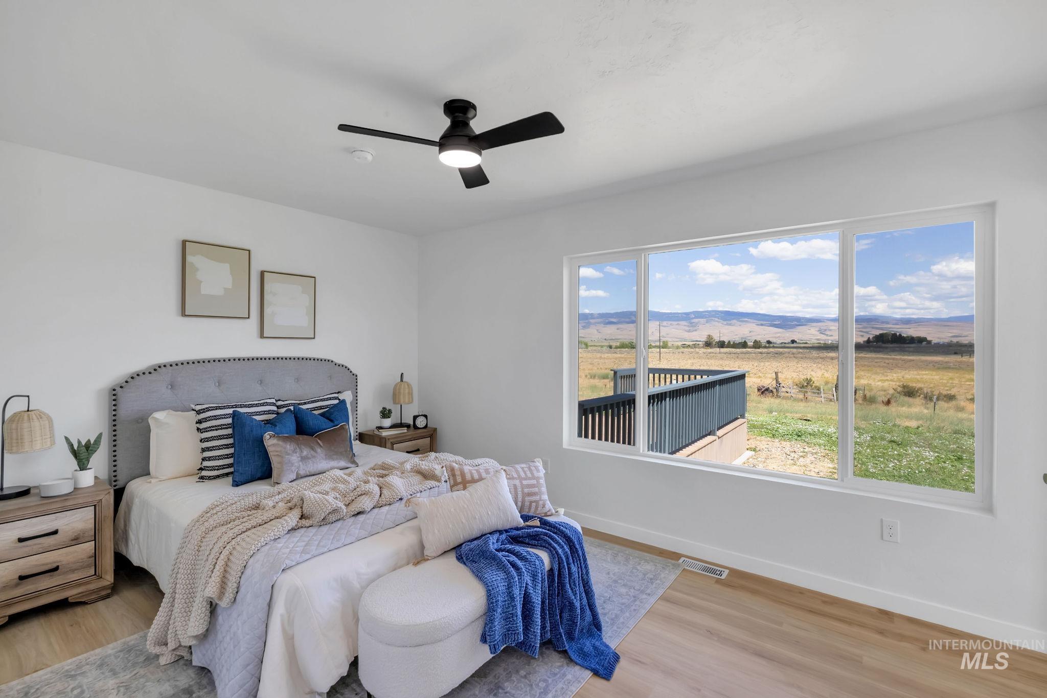 Bedroom featuring wood finished floors, a ceiling fan, and a mountain view