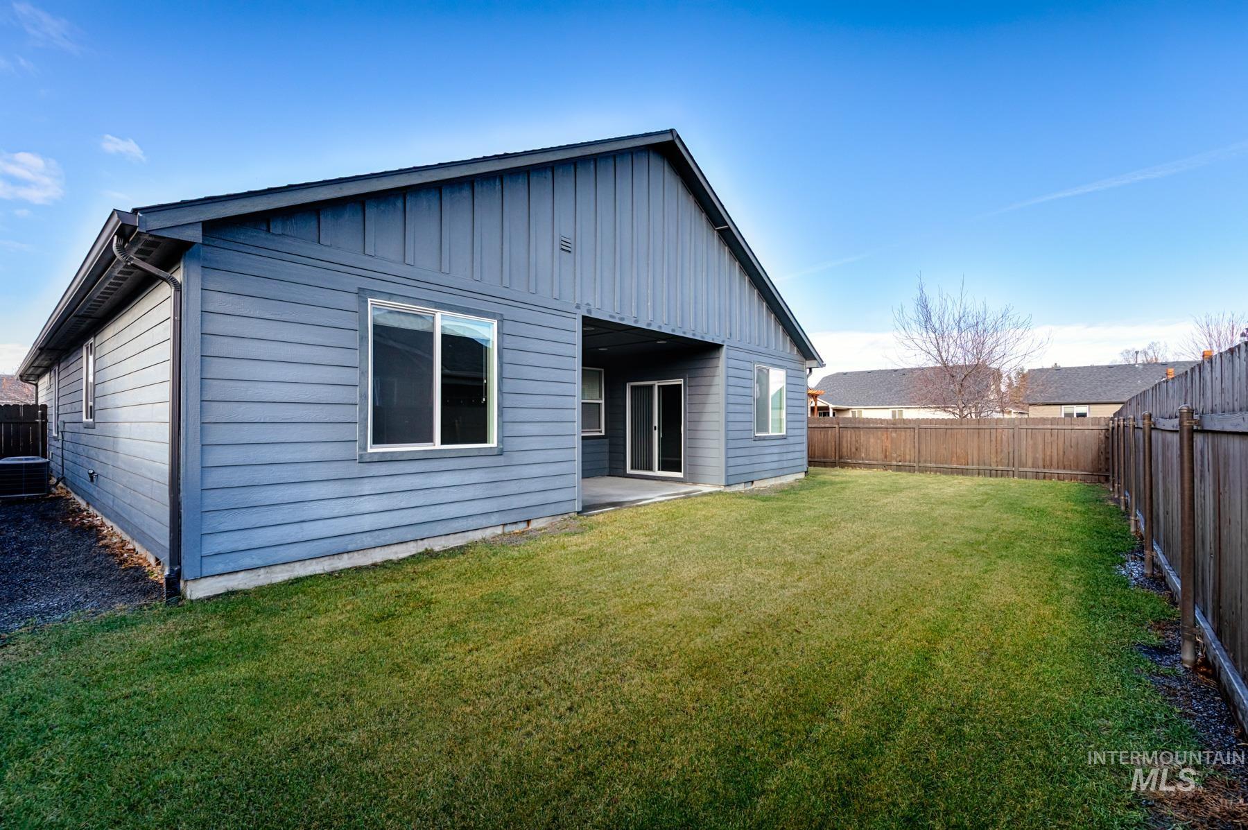 Back of property with a patio area, a fenced backyard, and board and batten siding