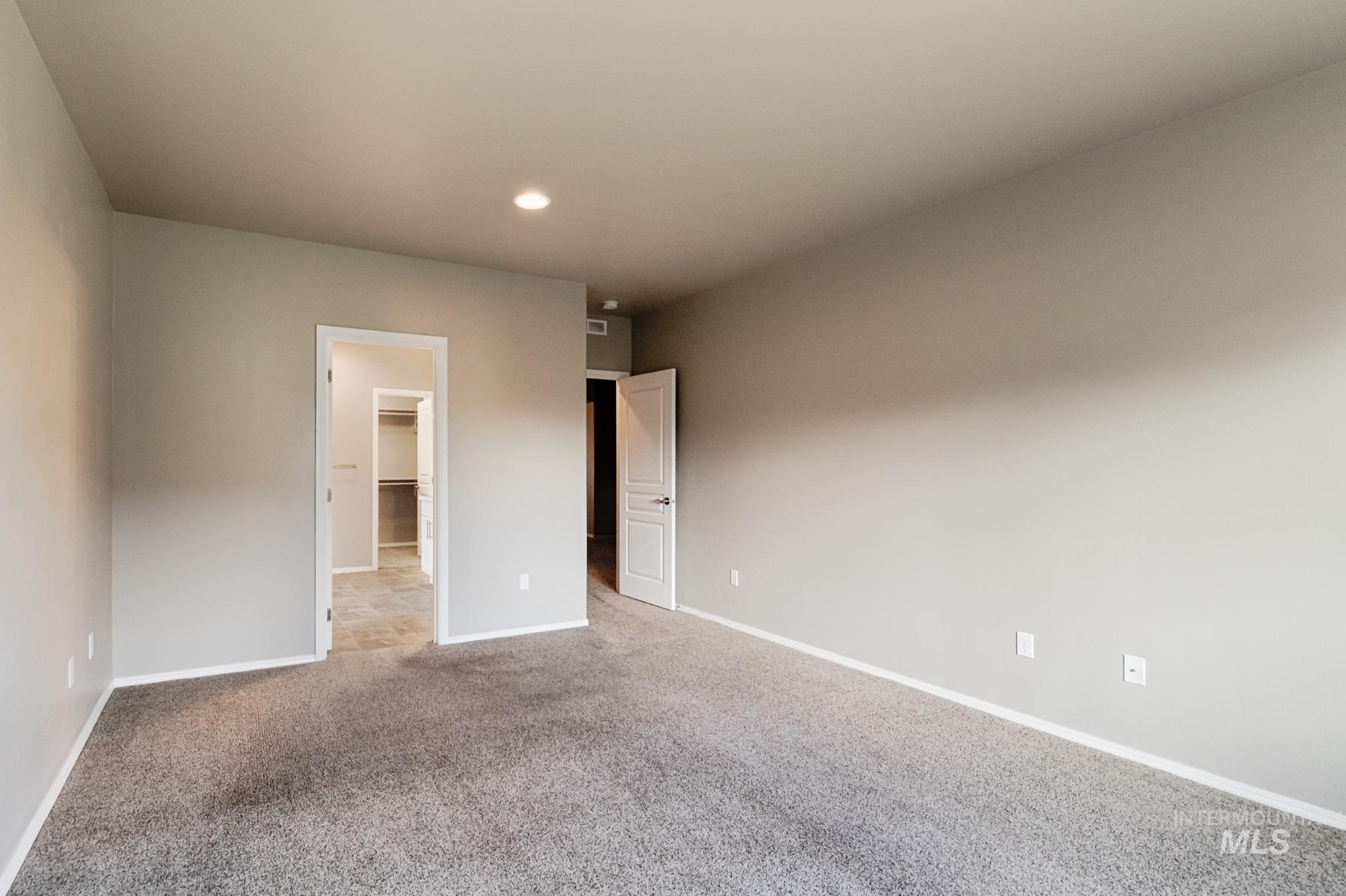 Unfurnished bedroom with carpet floors, a spacious closet, and recessed lighting