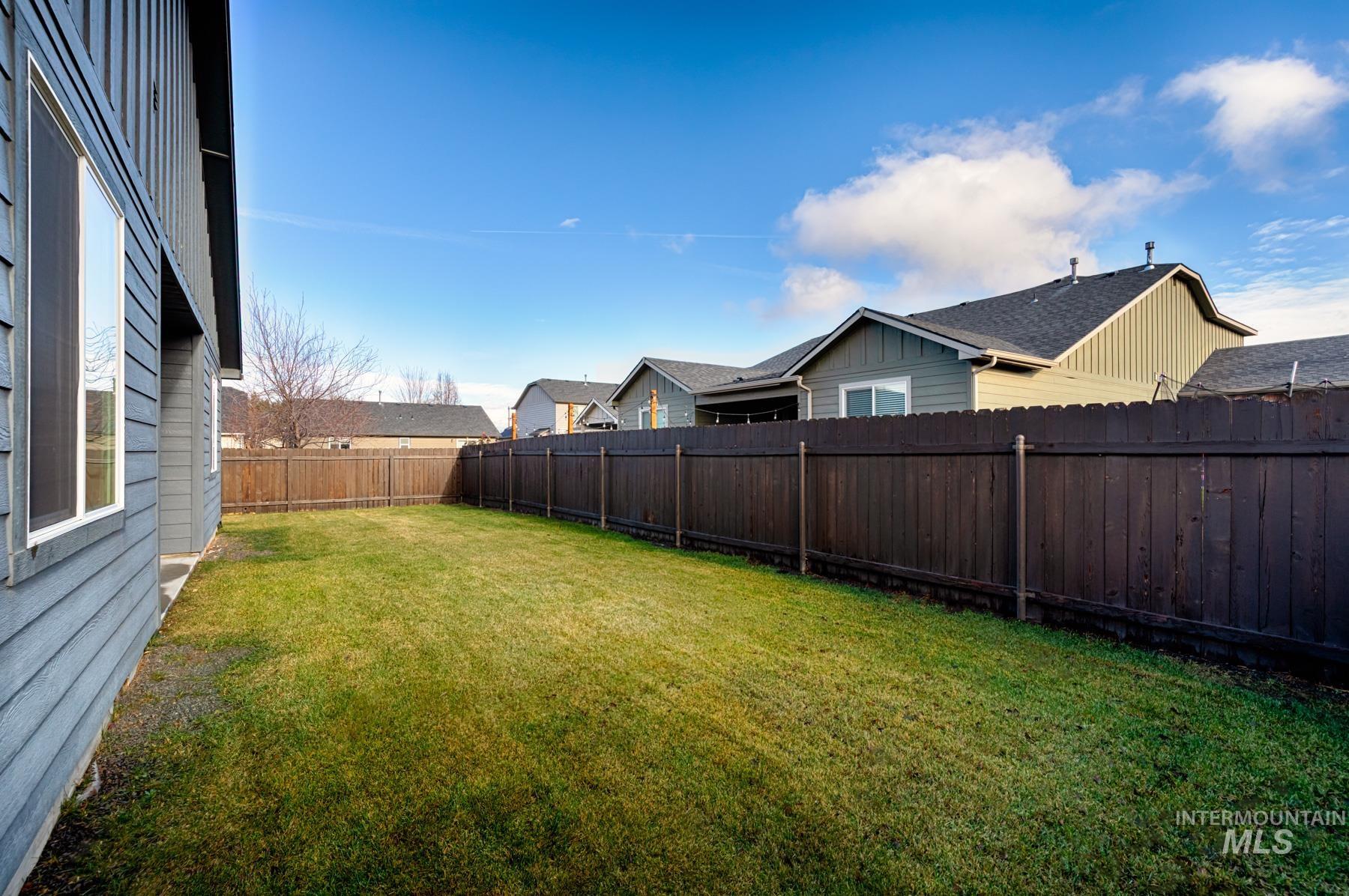 Fenced backyard featuring a residential view