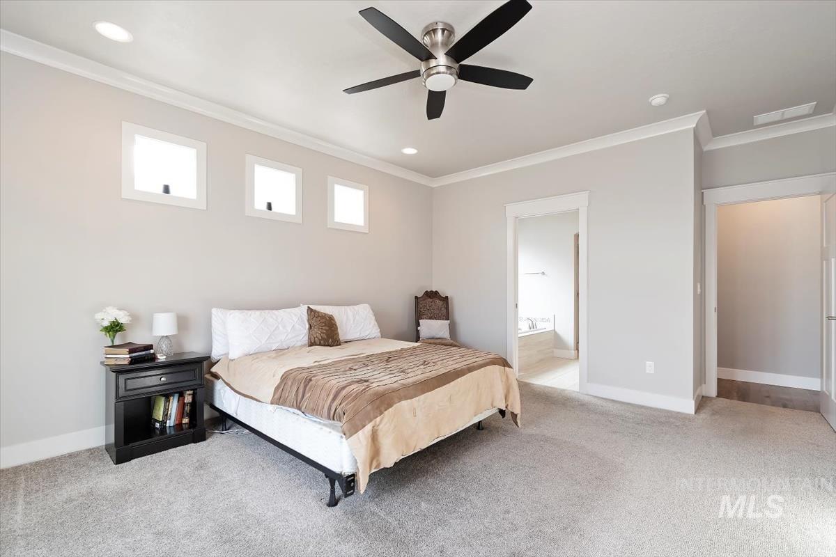 Bedroom with ornamental molding, light carpet, a ceiling fan, and recessed lighting