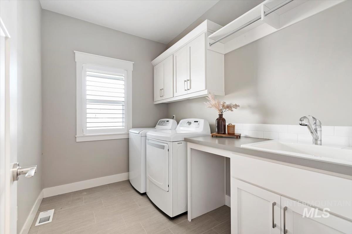 Washroom featuring cabinet space and separate washer and dryer