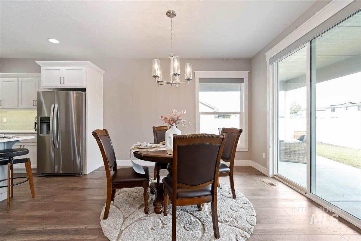 Dining area with a chandelier, dark wood finished floors, and recessed lighting