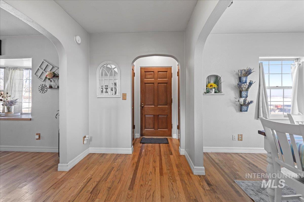 Foyer with wood finished floors and arched walkways