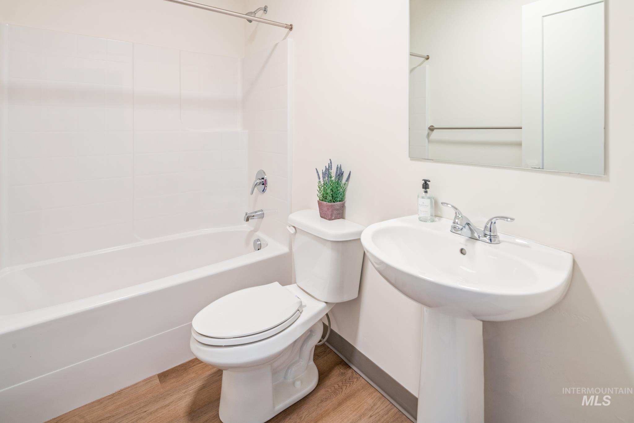 Full bathroom with light wood-type flooring and tub / shower combination