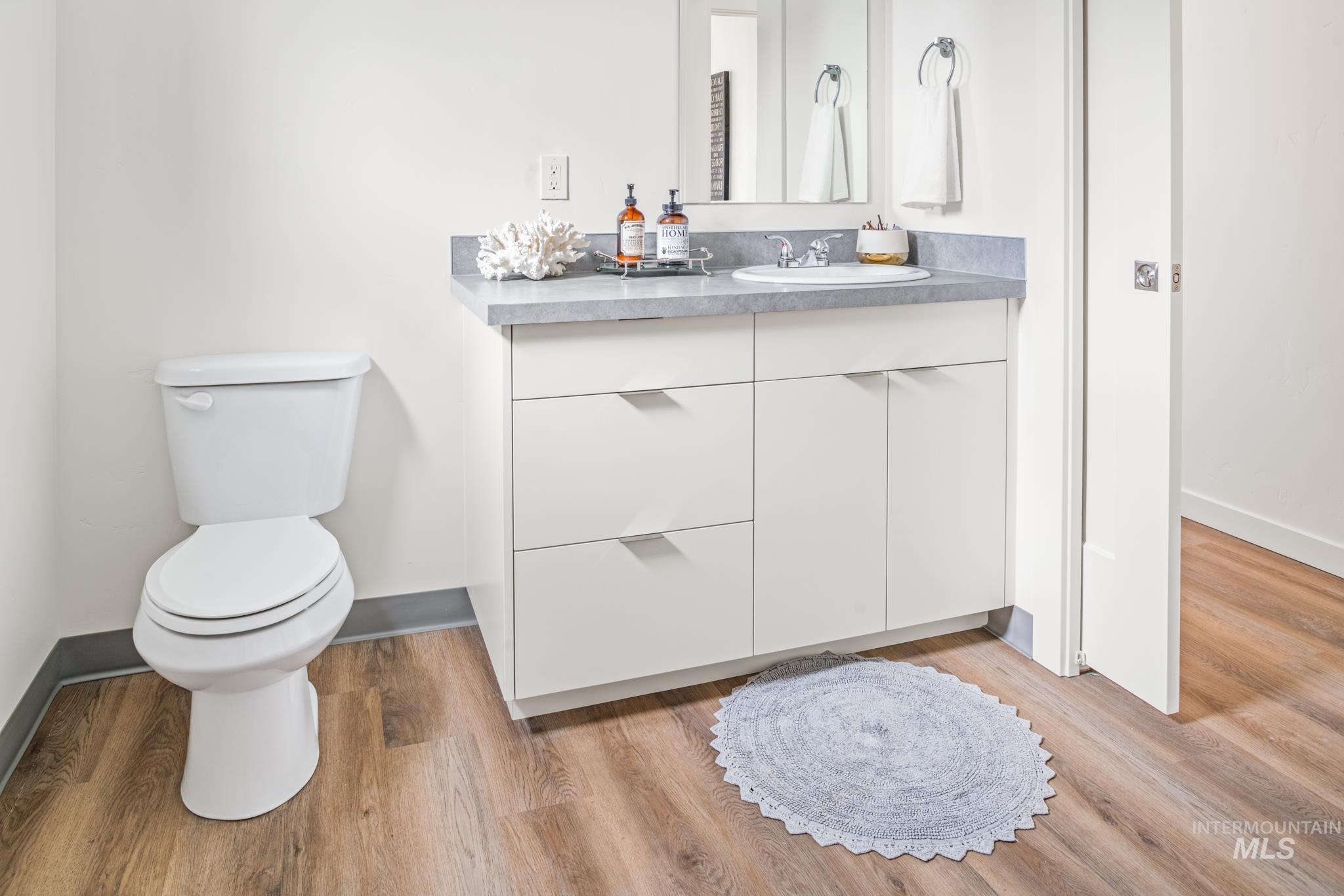 Half bathroom featuring vanity and light wood-type flooring