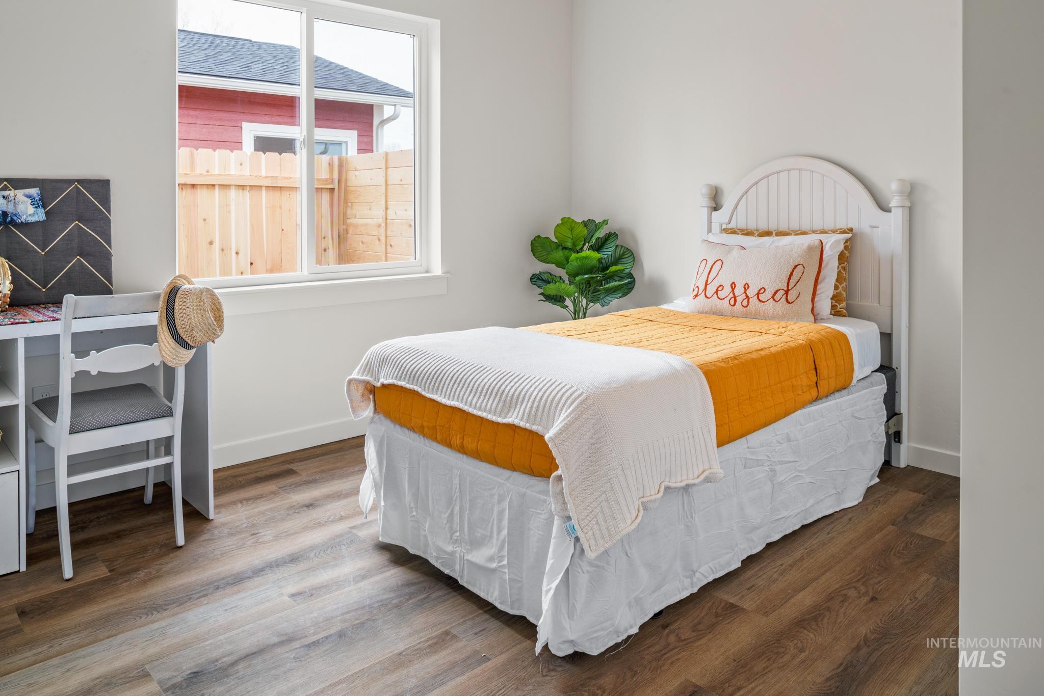 Bedroom featuring wood finished floors and baseboards