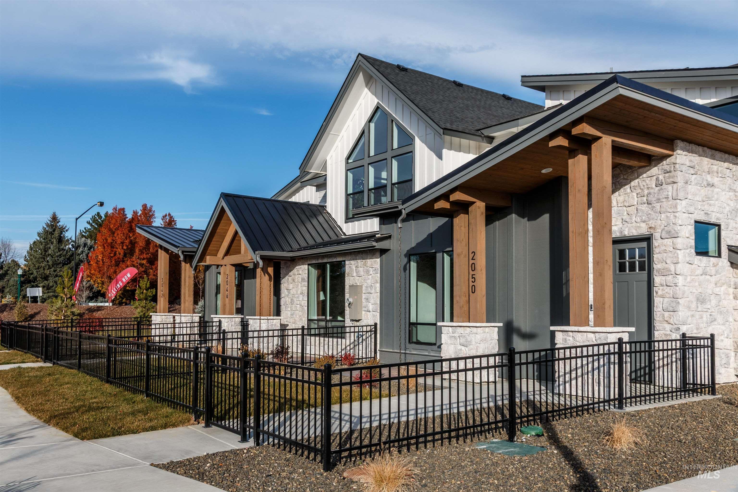 View of side of home featuring stone siding, a standing seam roof, a metal roof, and a porch