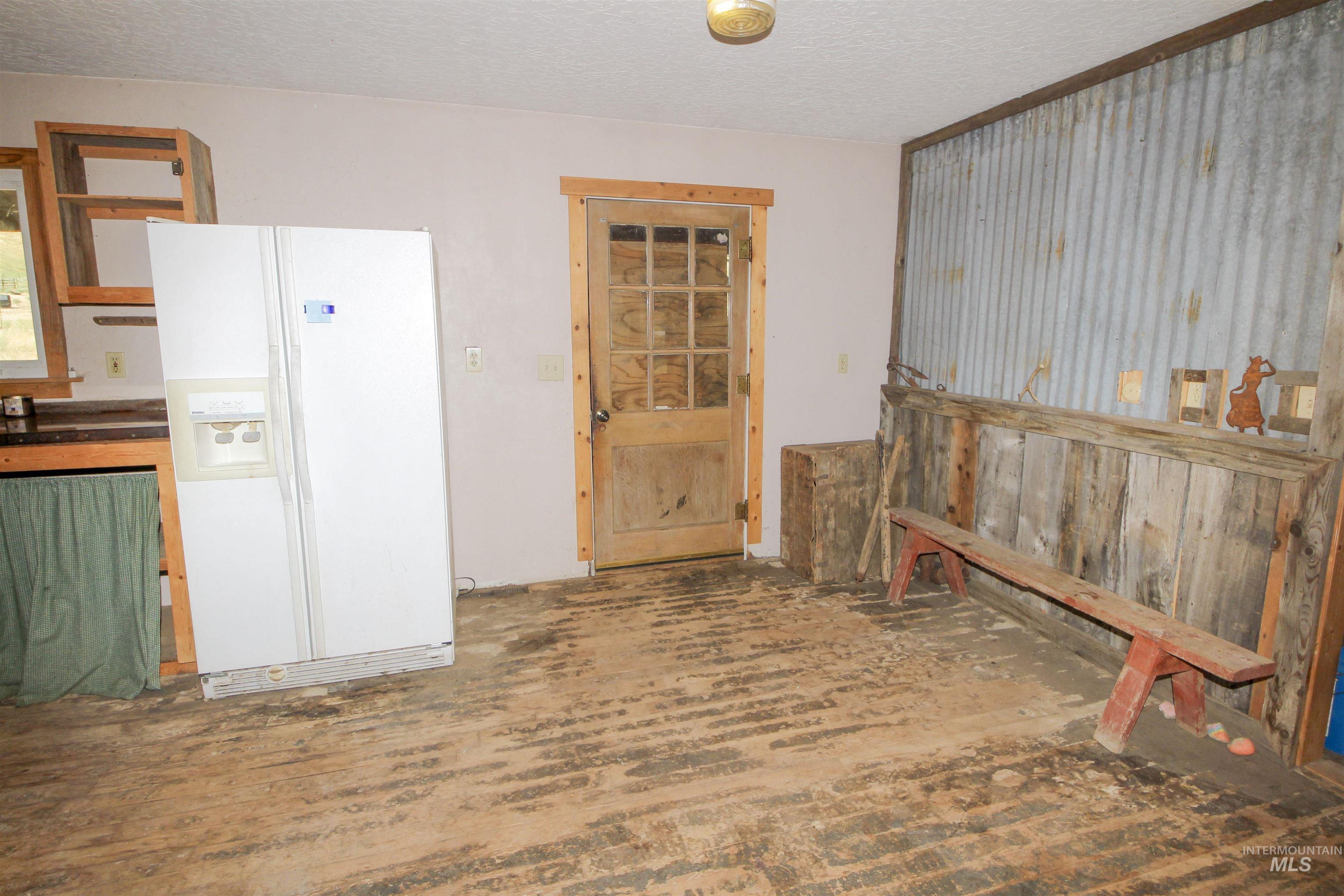 Kitchen with white fridge with ice dispenser, a textured ceiling, and dark countertops