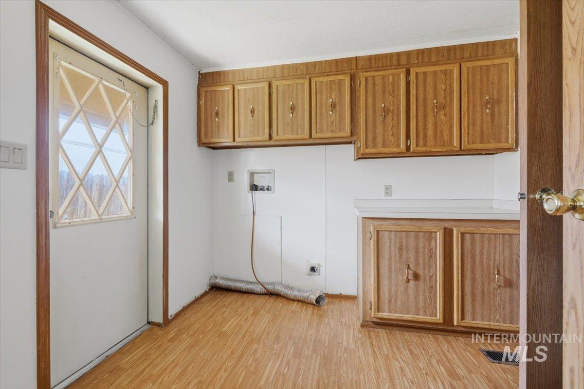 Laundry room featuring light wood-type flooring, cabinet space, and hookup for a washing machine