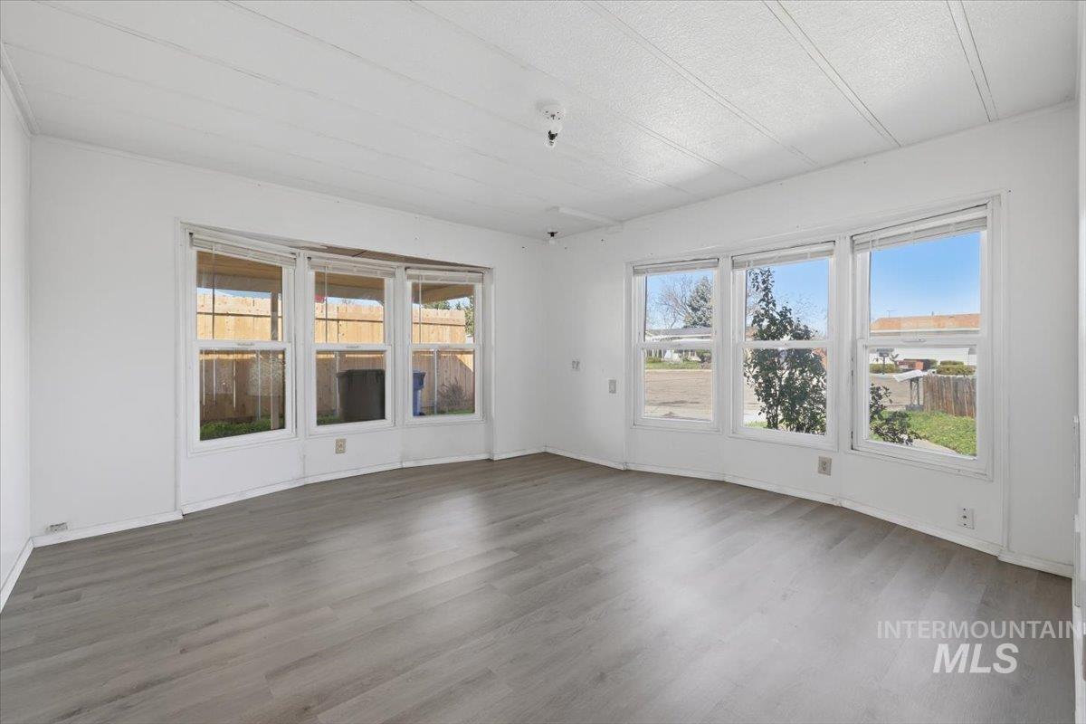 Unfurnished room featuring dark wood finished floors and baseboards