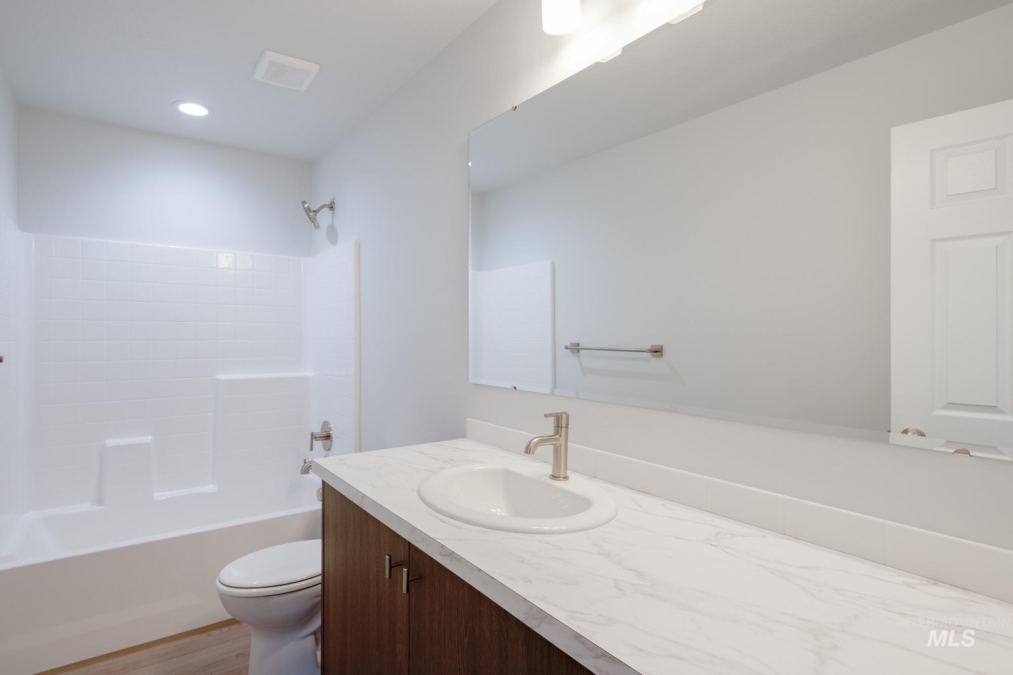 Full bathroom with vanity,  shower combination, and light wood-type flooring