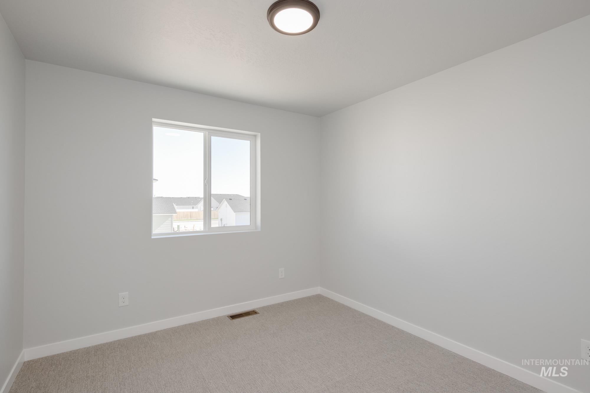 Spare room featuring baseboards and light carpet