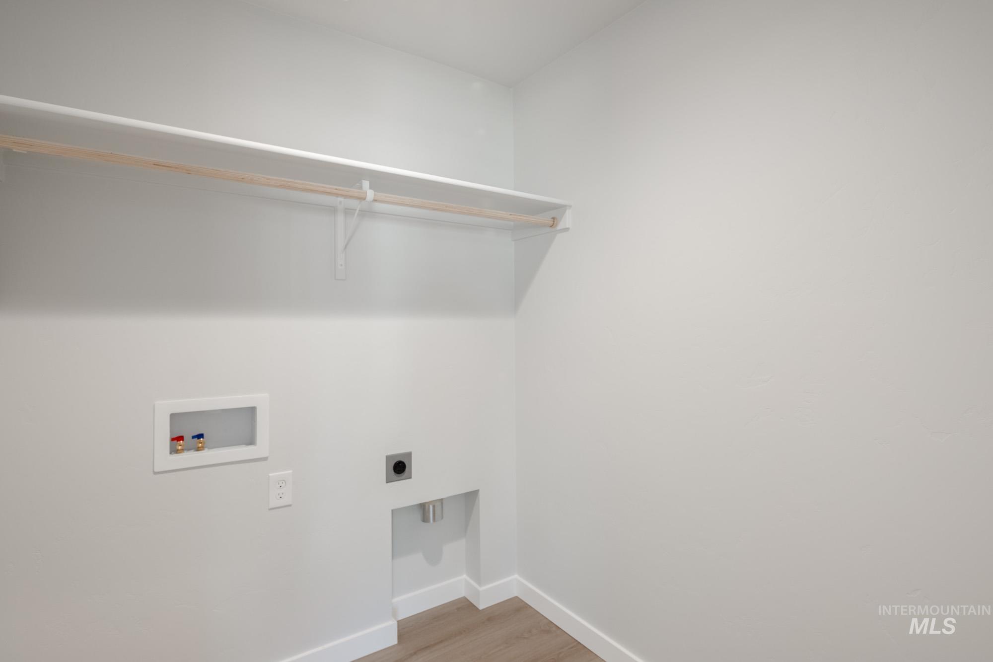 Laundry area featuring light wood-style flooring, hookup for an electric dryer, and hookup for a washing machine
