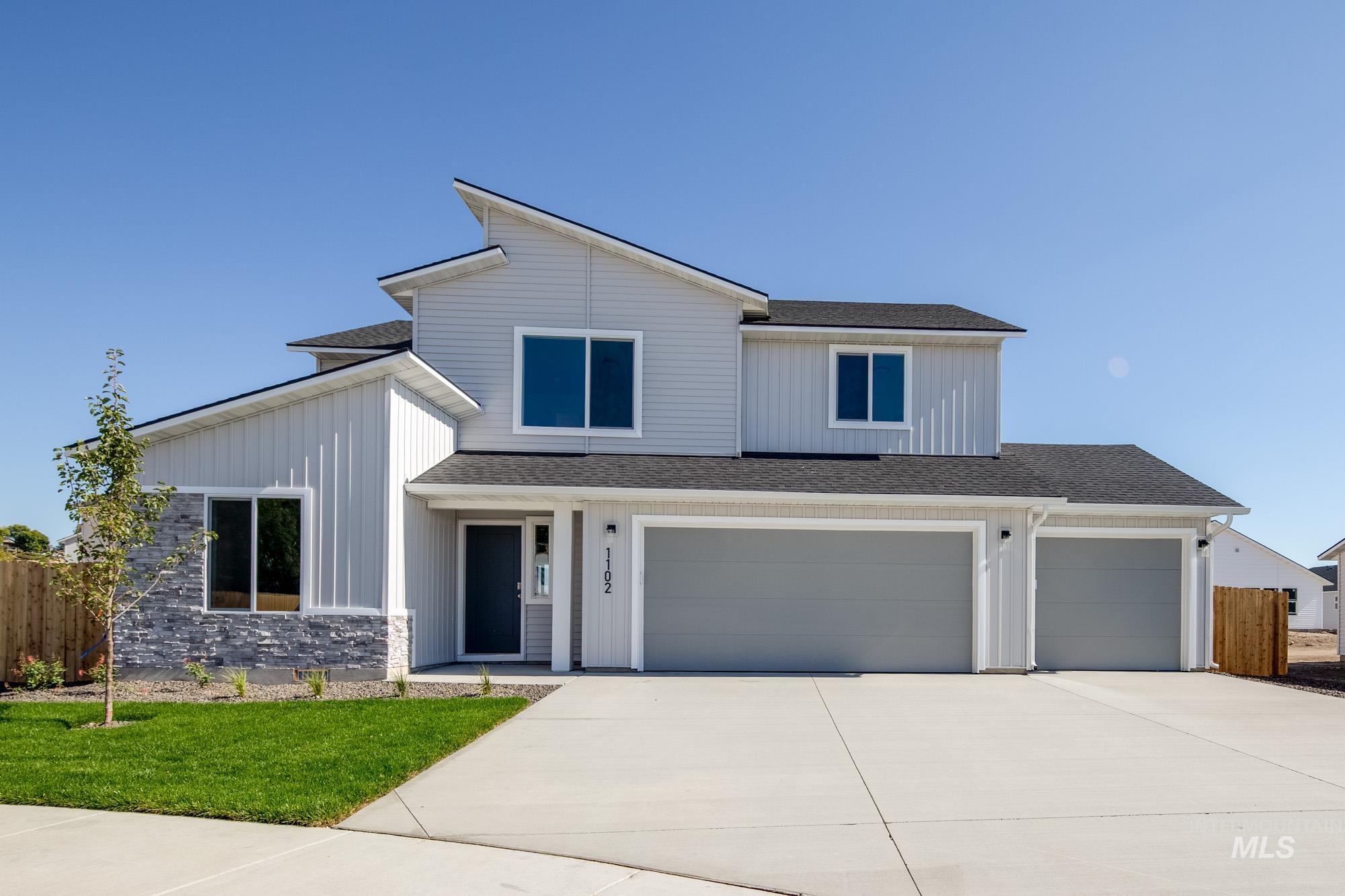 View of front of house with roof with shingles, concrete driveway, covered porch, and a garage