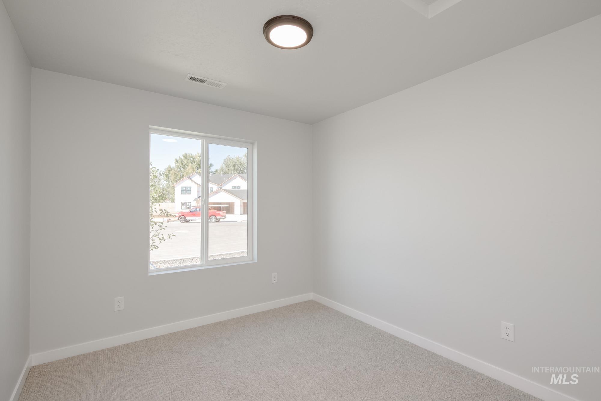 Empty room featuring baseboards and light carpet