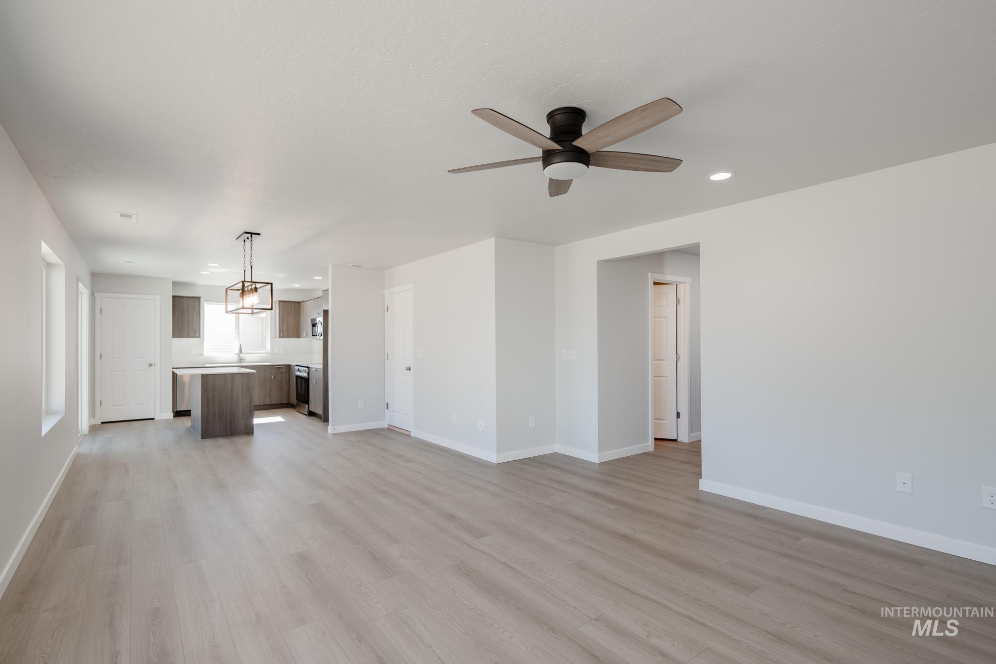 Unfurnished living room featuring light wood-style floors, recessed lighting, and a ceiling fan