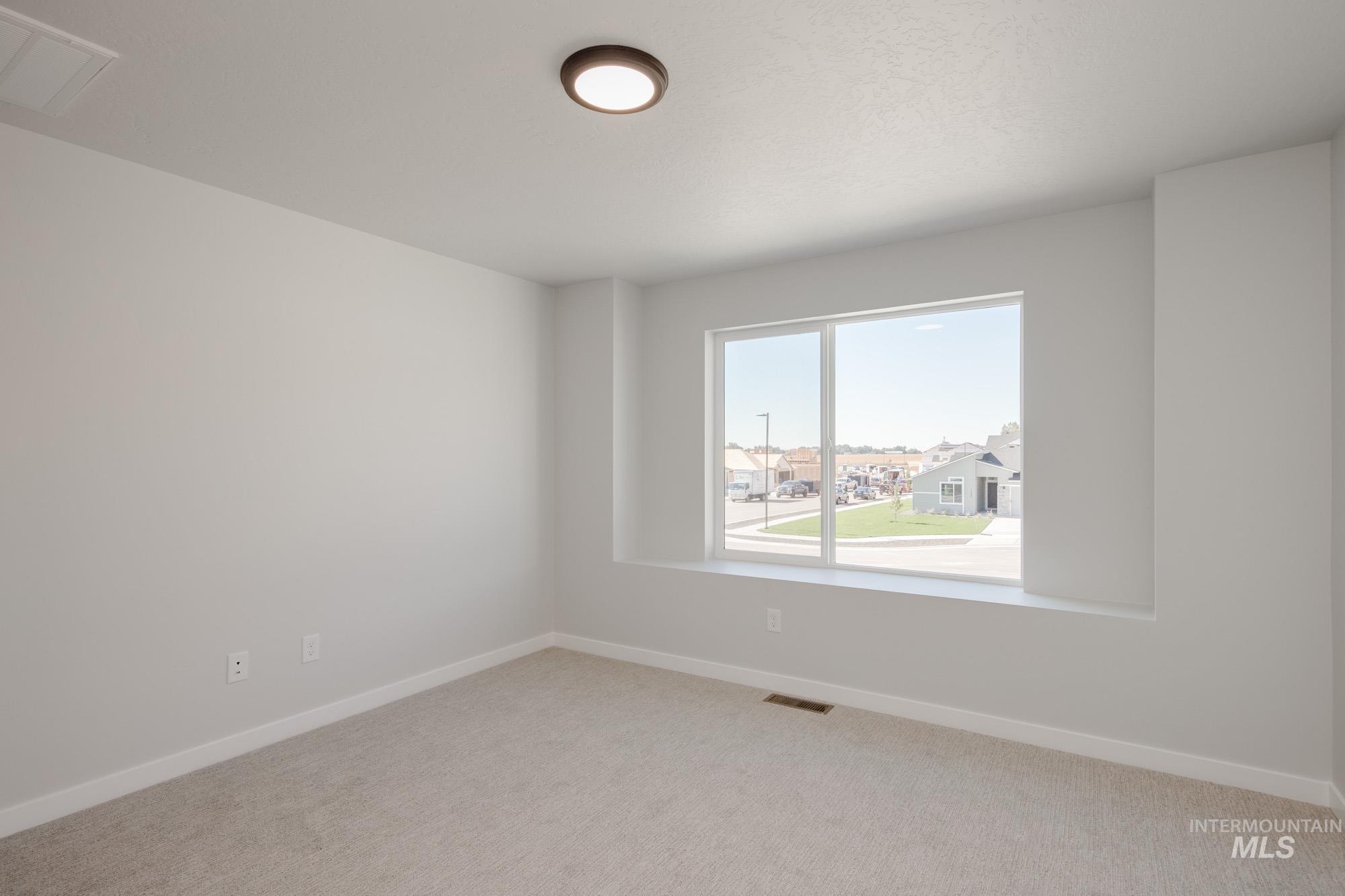 Empty room with baseboards and light colored carpet