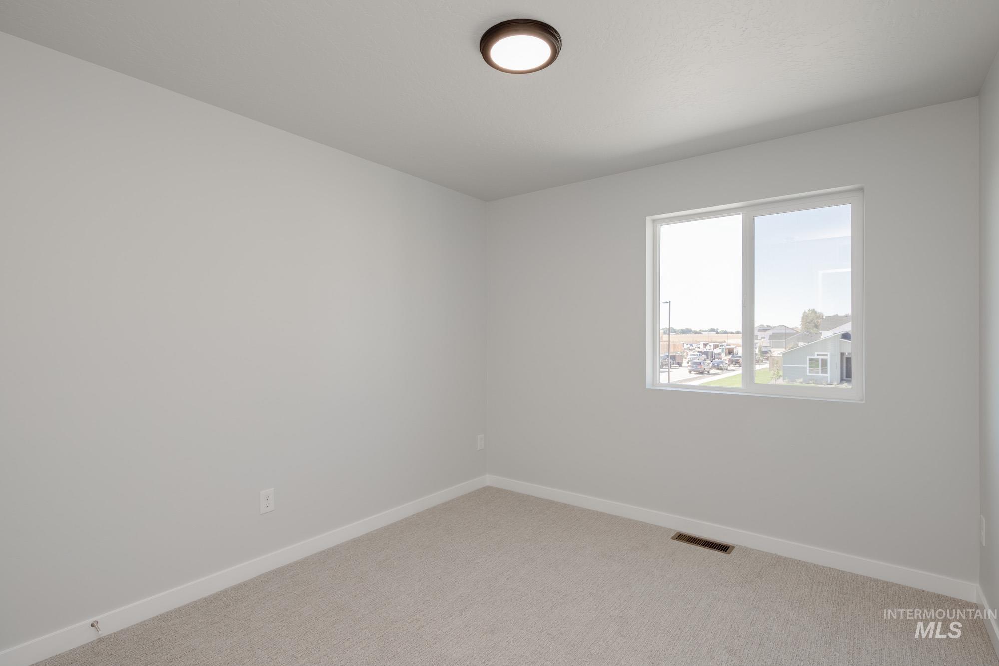 Spare room featuring baseboards and carpet