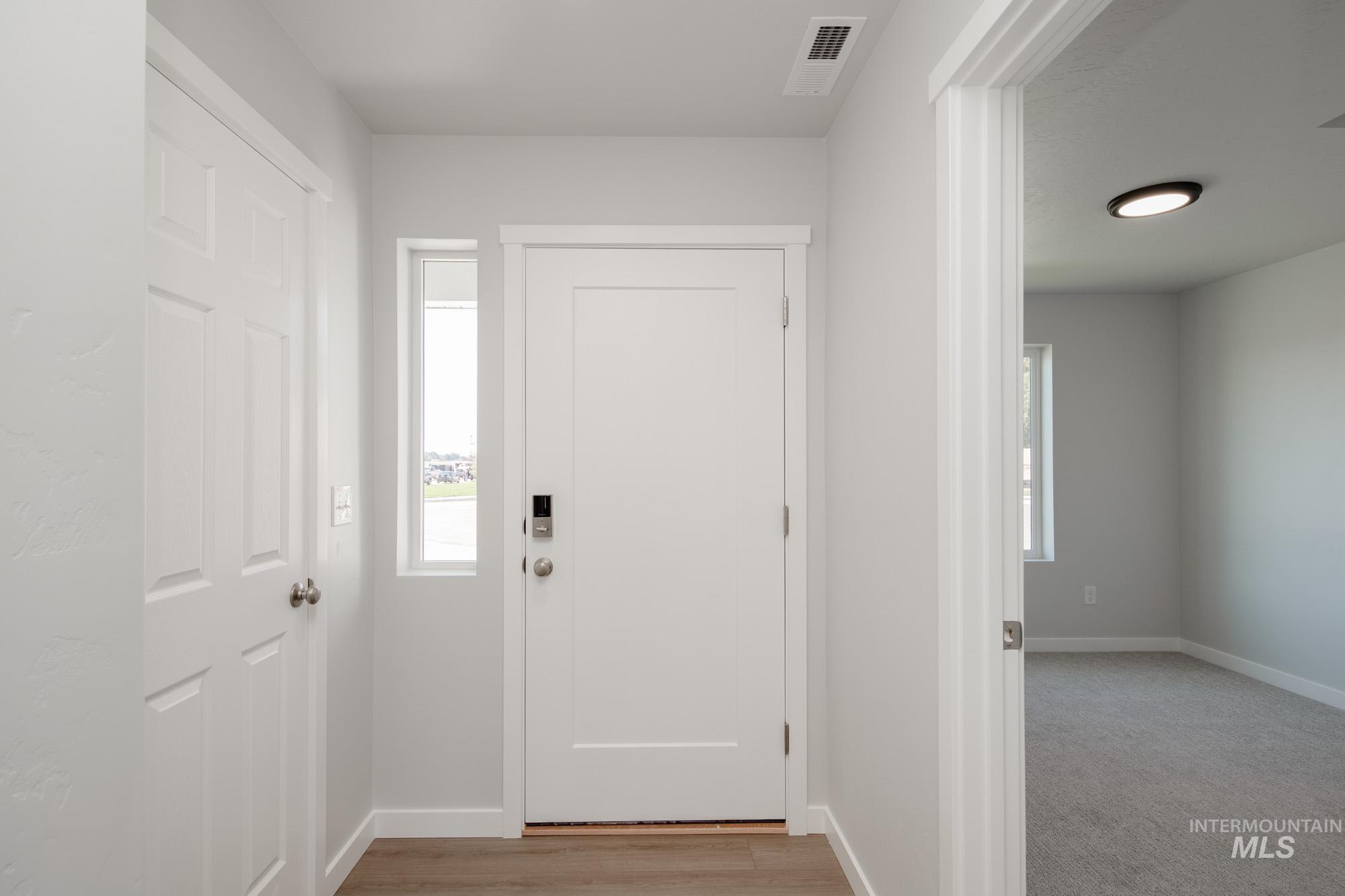Foyer entrance featuring plenty of natural light and light wood-type flooring