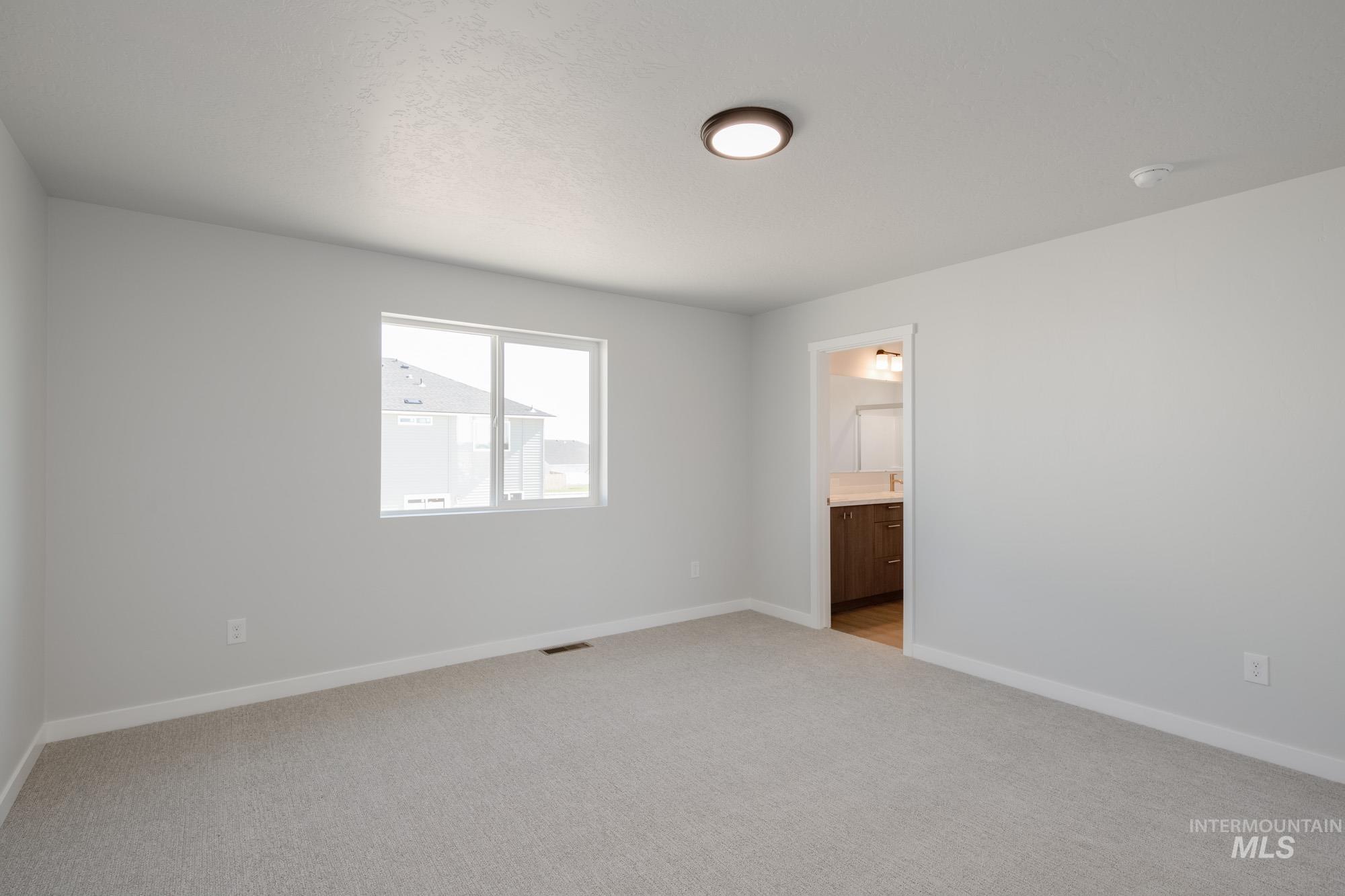 Empty room featuring light carpet and baseboards