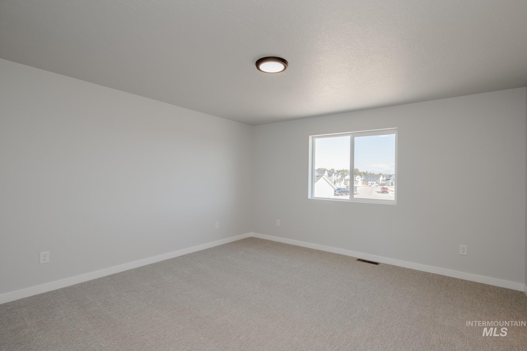 Empty room featuring baseboards and light carpet