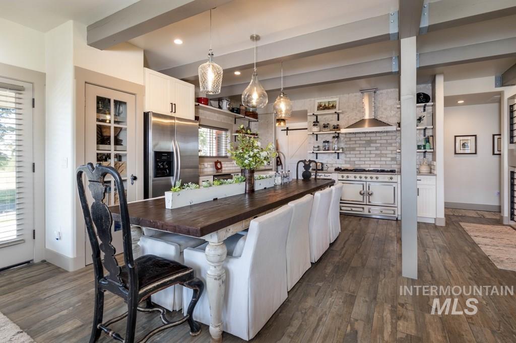 Kitchen featuring a kitchen breakfast bar, butcher block counters, white cabinets, stainless steel refrigerator with ice dispenser, and backsplash