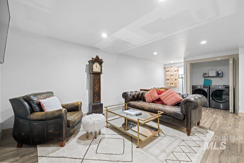 Living room with wood finished floors, recessed lighting, and separate washer and dryer