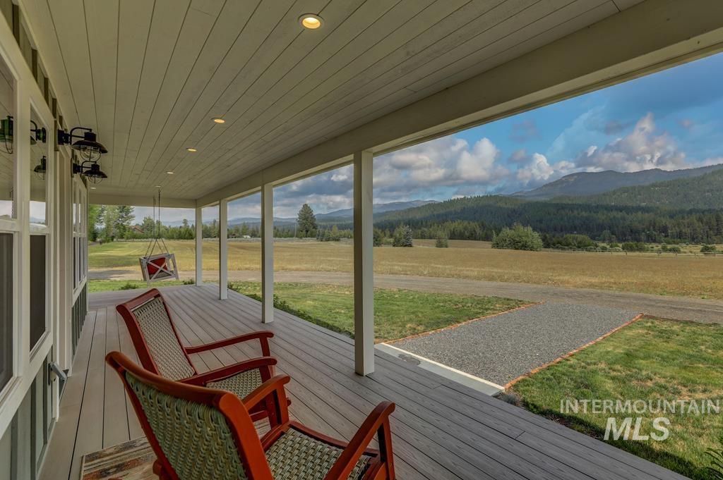 Wooden terrace featuring a mountain view and a yard