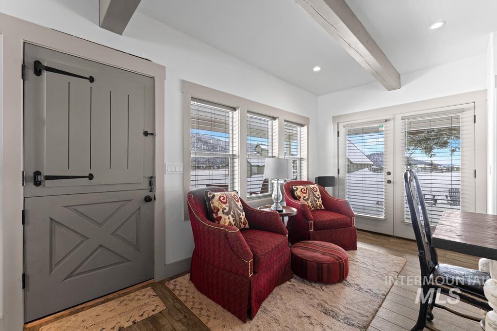 Interior space with beamed ceiling, wood finished floors, french doors, and recessed lighting