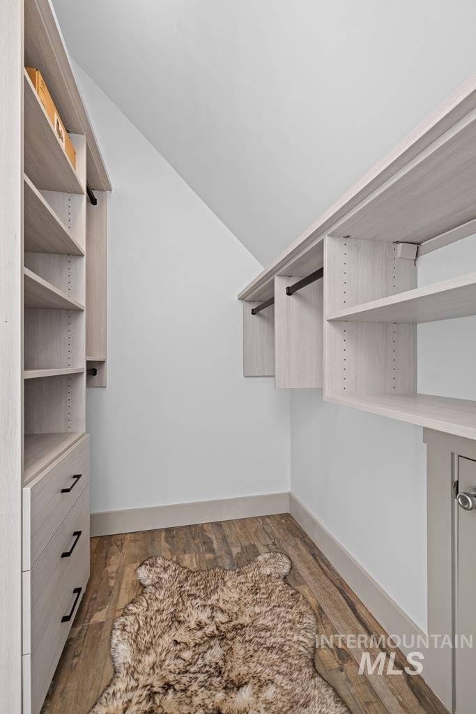Walk in closet featuring light wood finished floors and vaulted ceiling