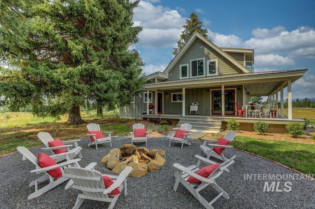 Back of house with an outdoor fire pit, board and batten siding, a large porch, and a patio area