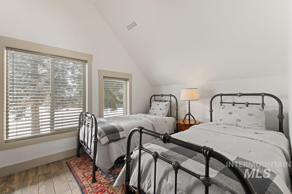 Bedroom featuring lofted ceiling and hardwood / wood-style flooring