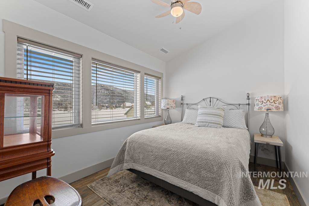 Bedroom with vaulted ceiling, ceiling fan, and wood finished floors