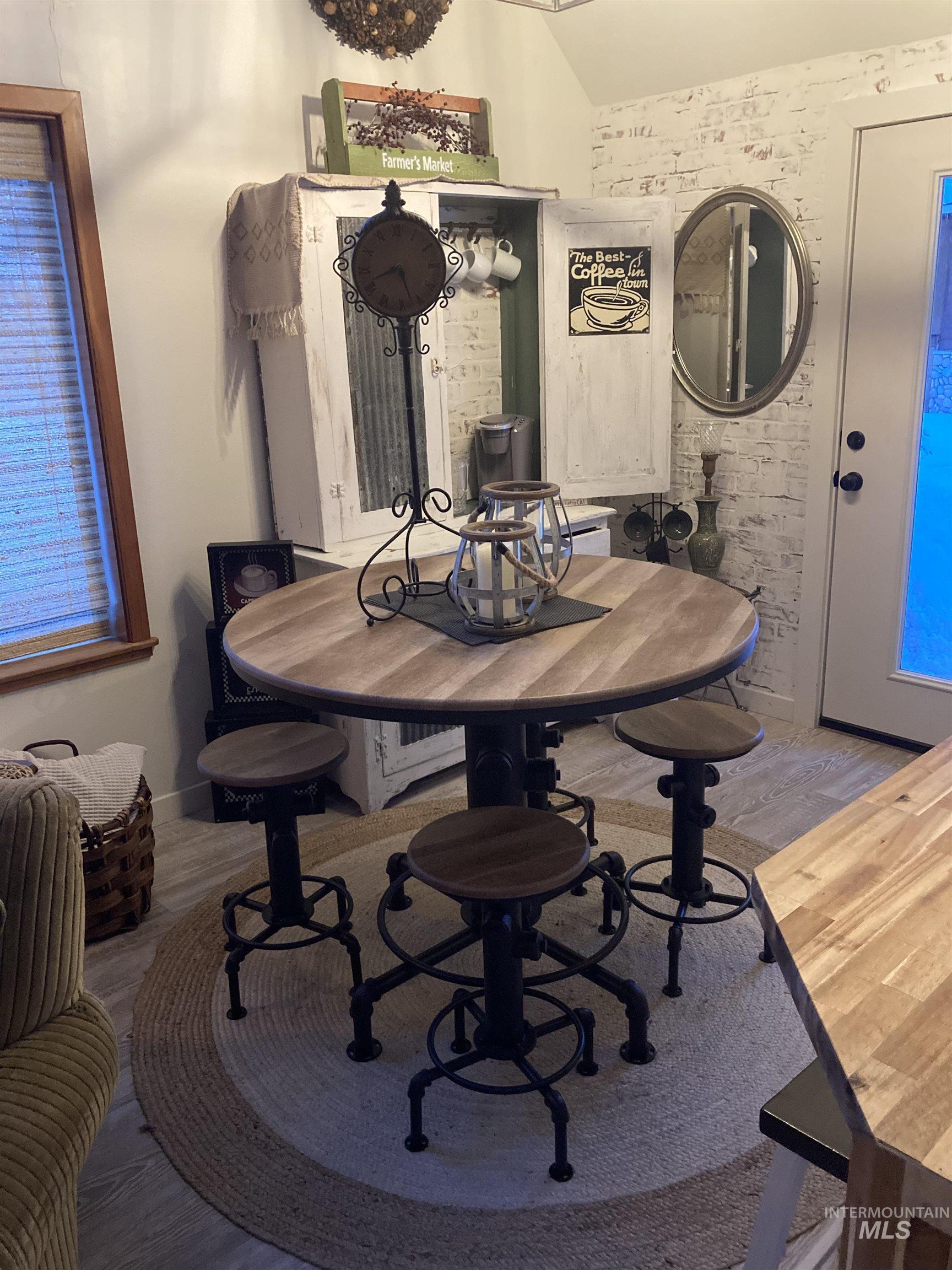 Dining area with vaulted ceiling and wood finished floors