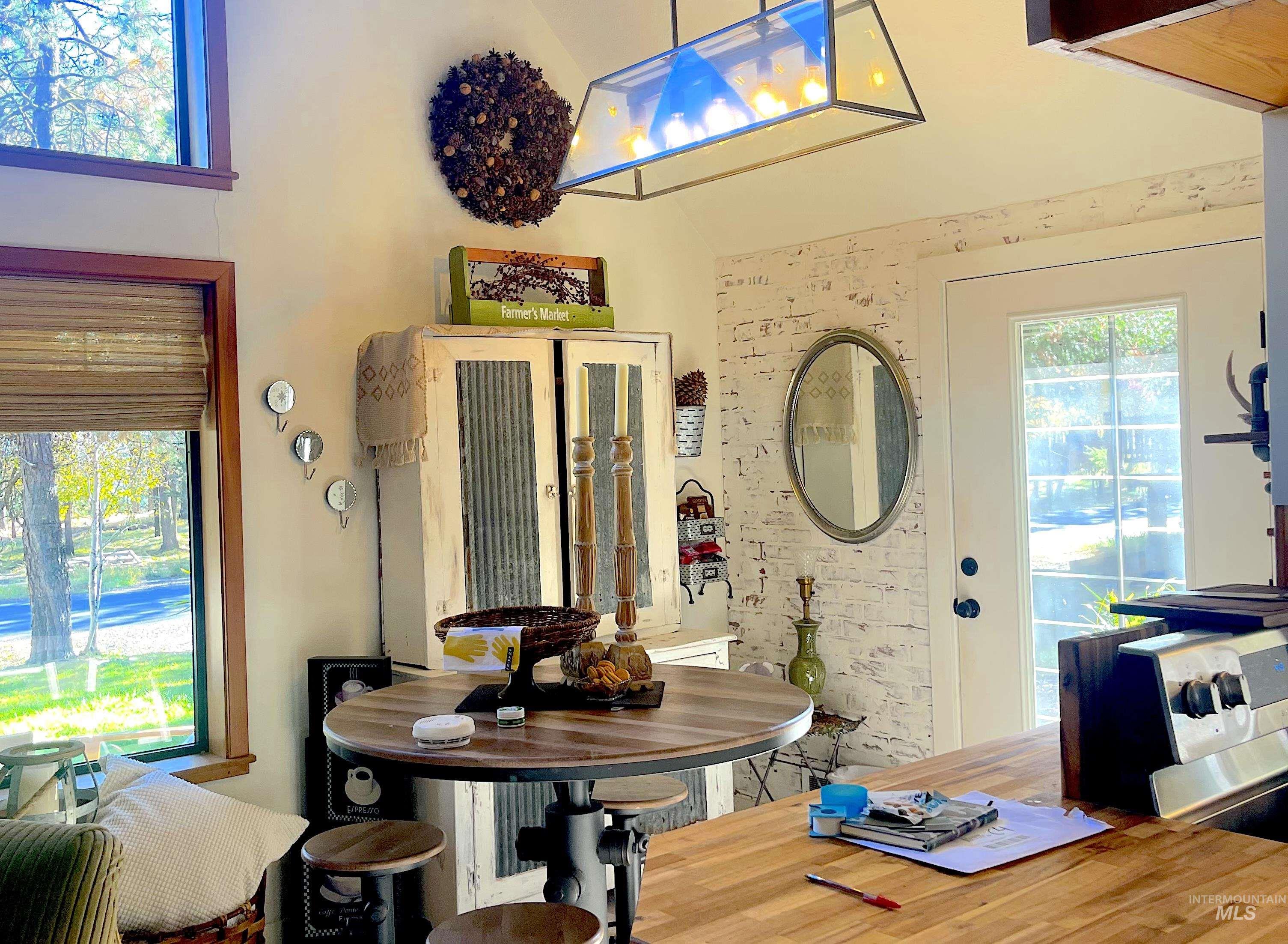 Dining room with healthy amount of natural light, a high ceiling, and wood finished floors