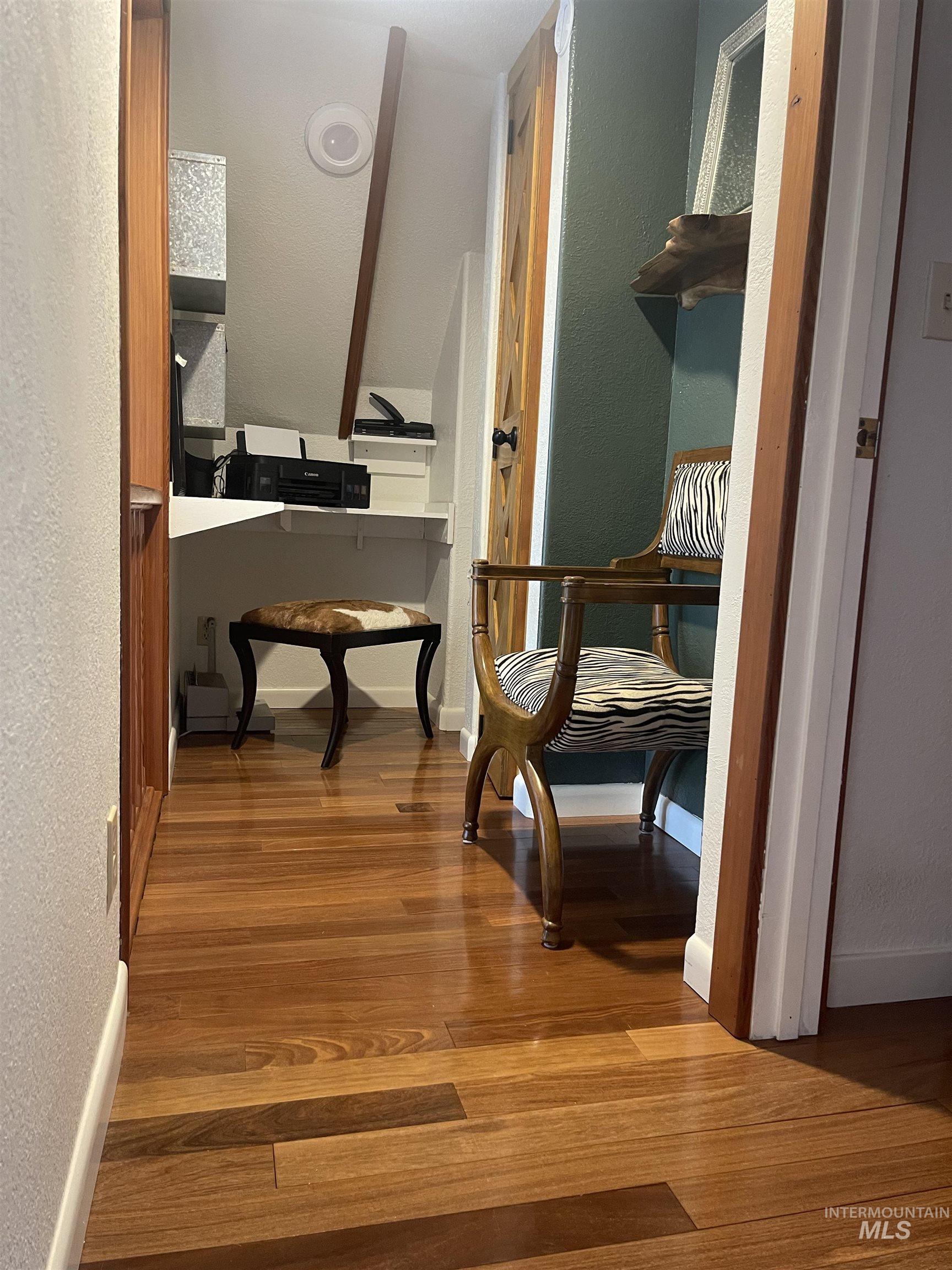 Sitting room with a textured wall and dark wood-style flooring