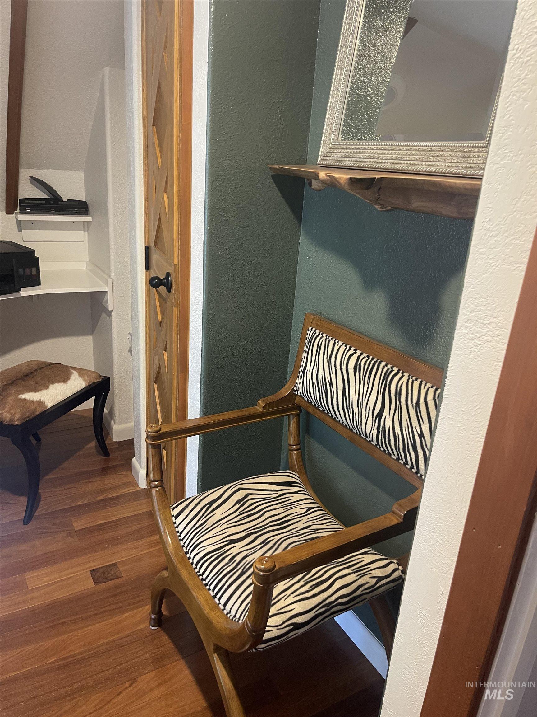 Sitting room with a textured wall and dark wood-type flooring