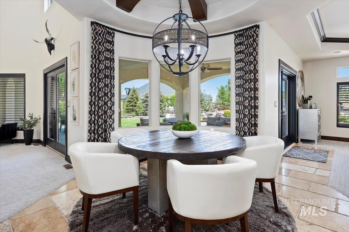Dining space featuring stone tile flooring and a chandelier