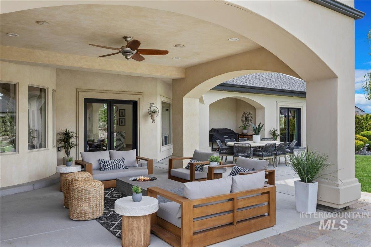 View of patio with an outdoor living space with a fire pit, a ceiling fan, and outdoor dining area
