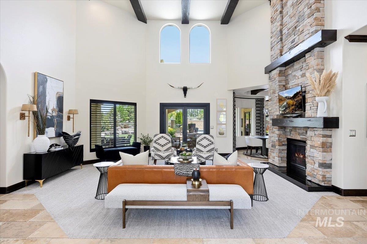 Living area featuring a fireplace, stone tile floors, and beam ceiling