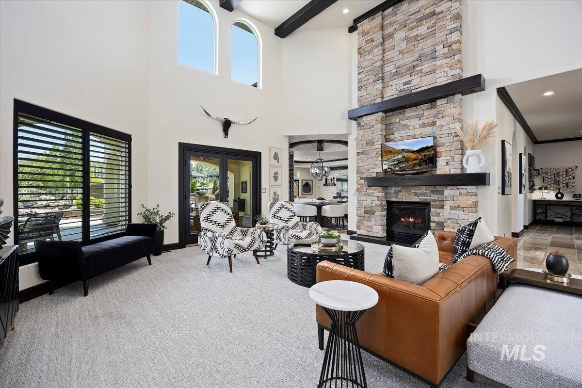 Living room with a fireplace, beamed ceiling, and carpet floors