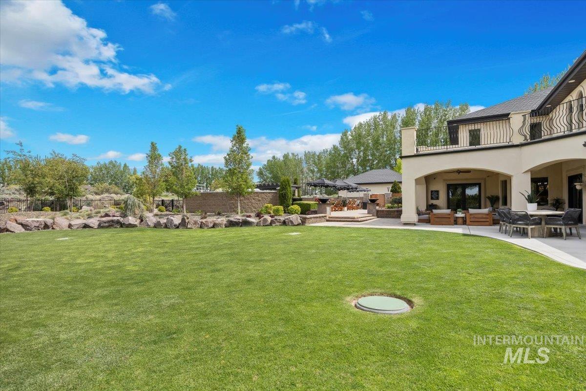 View of grassy yard featuring a patio area