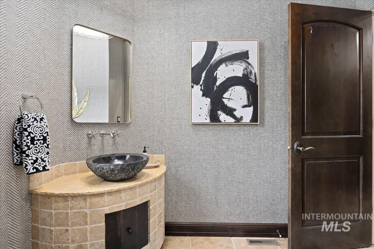 Bathroom with wallpapered walls and vanity