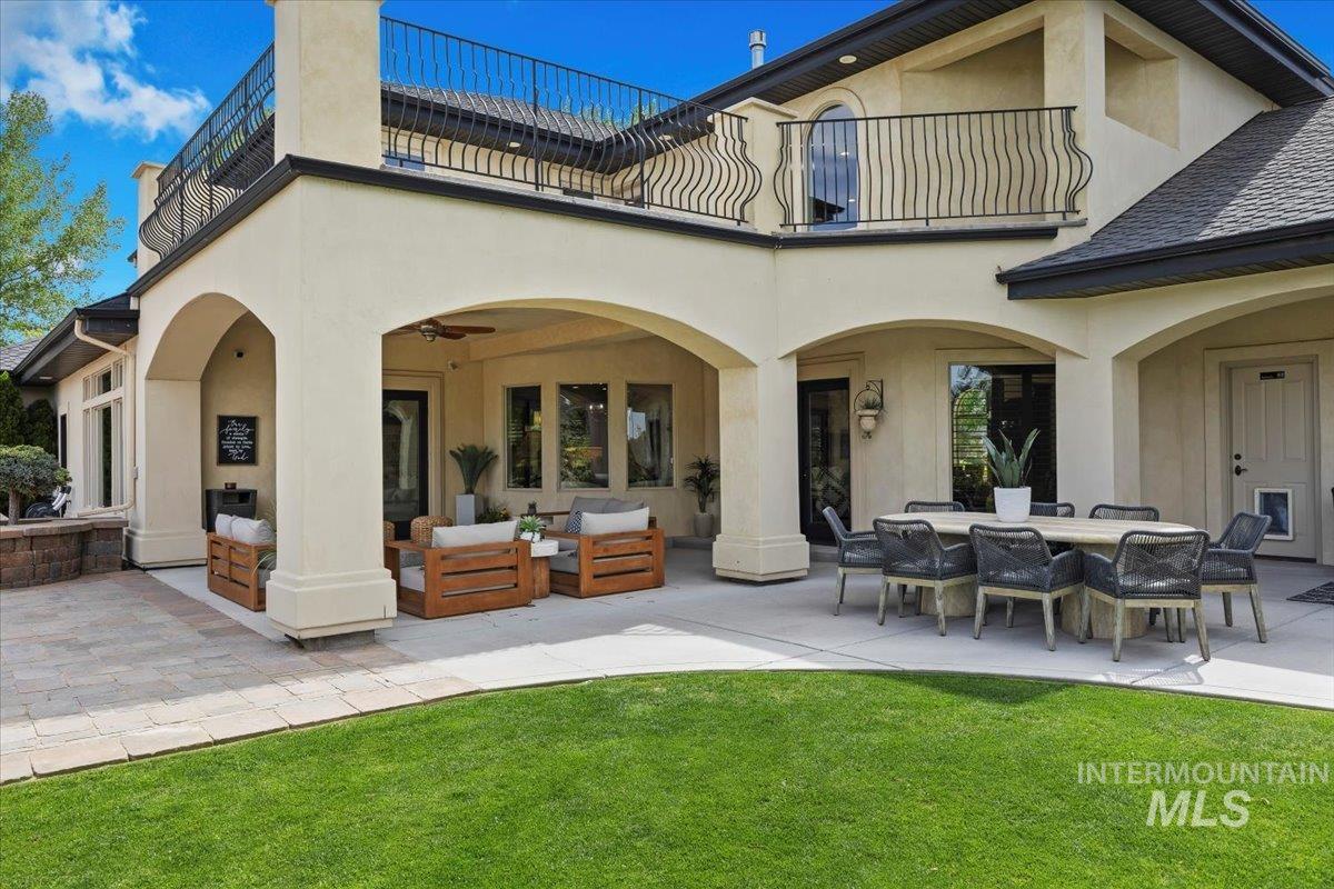 Back of house featuring a balcony, a patio, and an outdoor living space